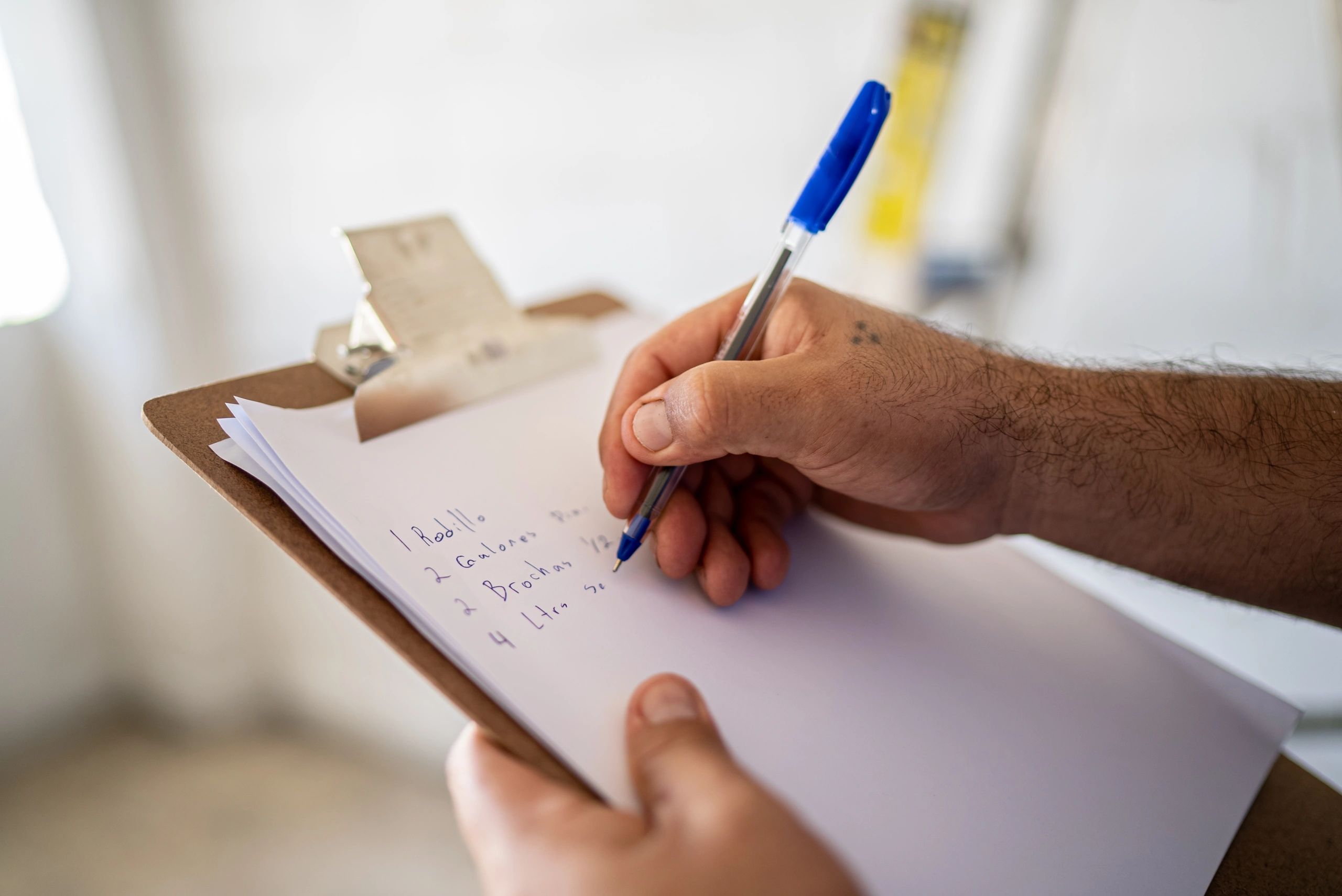 Contractor writing estimate notes on a clipboard