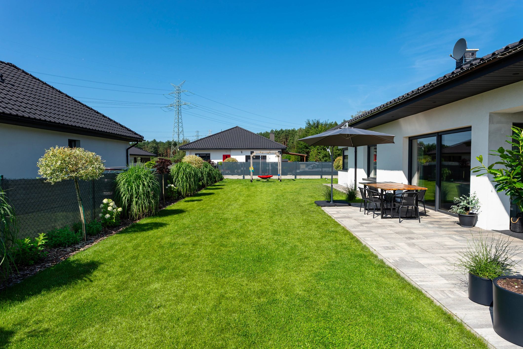 Backyard patio and lawn beside residential fencing